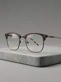 Club Master Frame – gunmetal browline with tortoise temples, 3/4 angle on stone surface