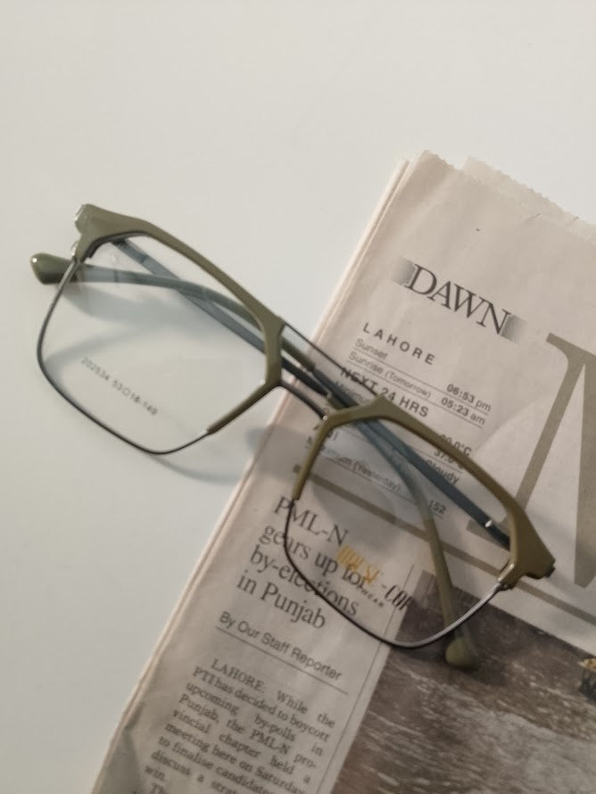 Olive green rectangular eyeglasses resting on a newspaper, modern optical frames for daily wear