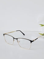 Stylish black and gold half-rim eyeglasses with clear lenses on white surface, modern optical frames