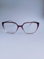 A pair of cat- eye eyeglasses with a translucent burgundy acetate frame that fades to clear at the bottom, shown against a light gray background.