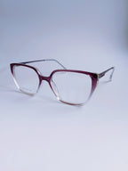 A pair of cat-eye eyeglasses with a translucent burgundy-to-clear gradient frame and clear lenses, displayed on a light gray gradient background.