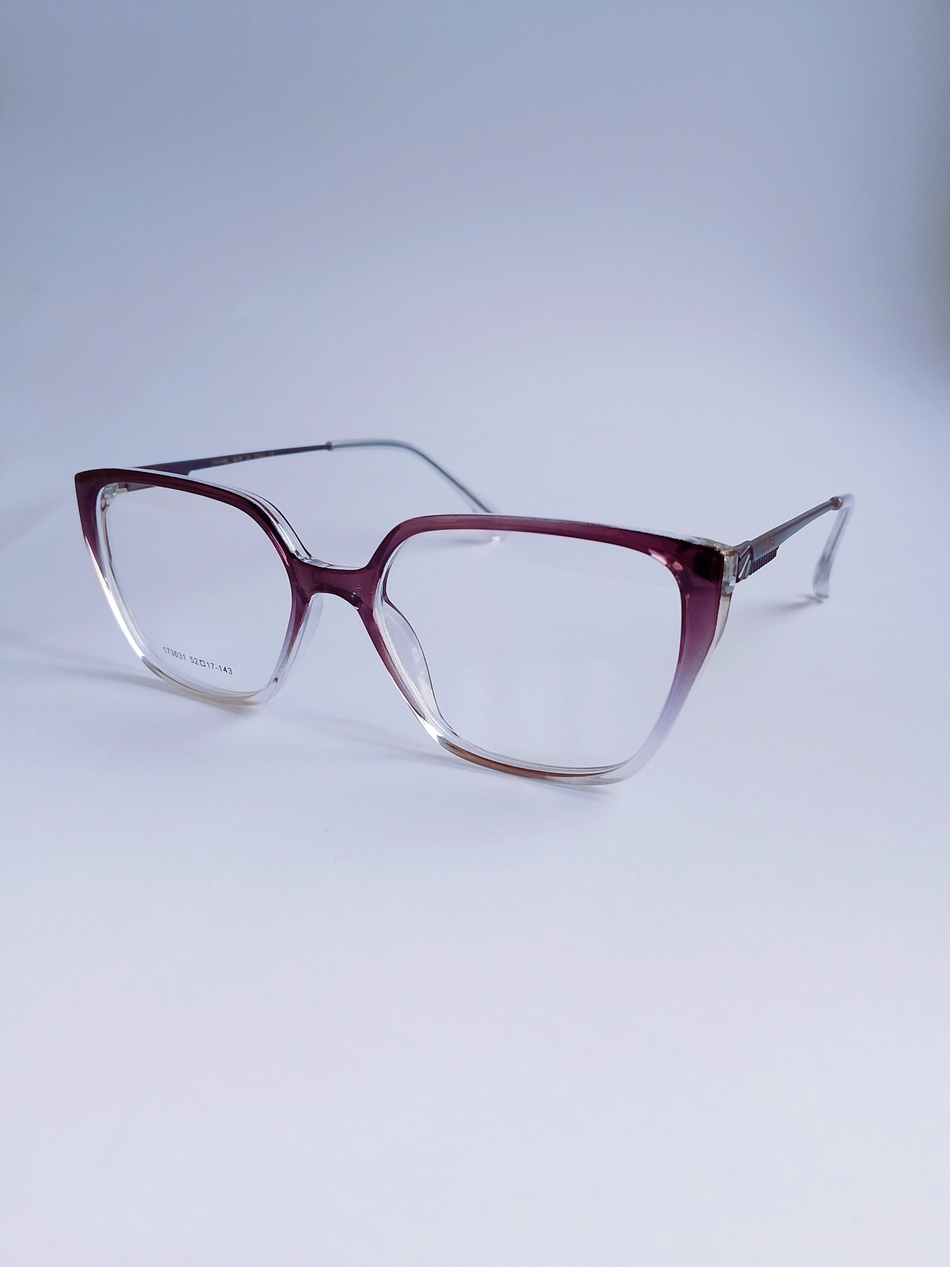 A pair of cat-eye eyeglasses with a translucent burgundy-to-clear gradient frame and clear lenses, displayed on a light gray gradient background.