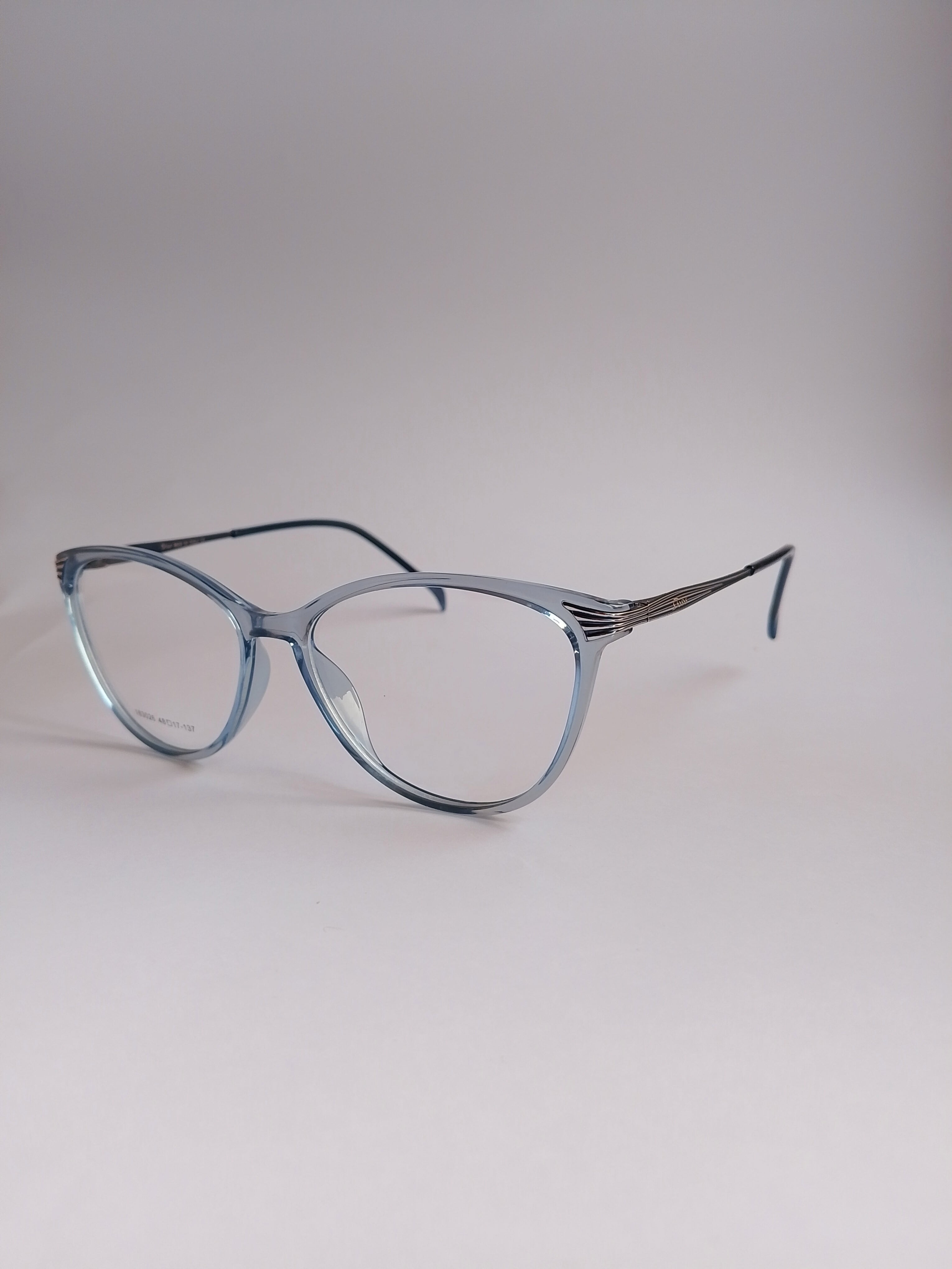 Light blue cat-eye eyeglasses with a translucent acetate frame and thin metal temples, displayed on a neutral light gray background.
