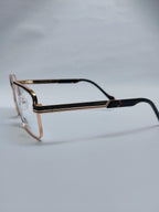 A pair of eyeglasses with a gold-tone metal frame and dark tortoiseshell temples, displayed on a light gray background.