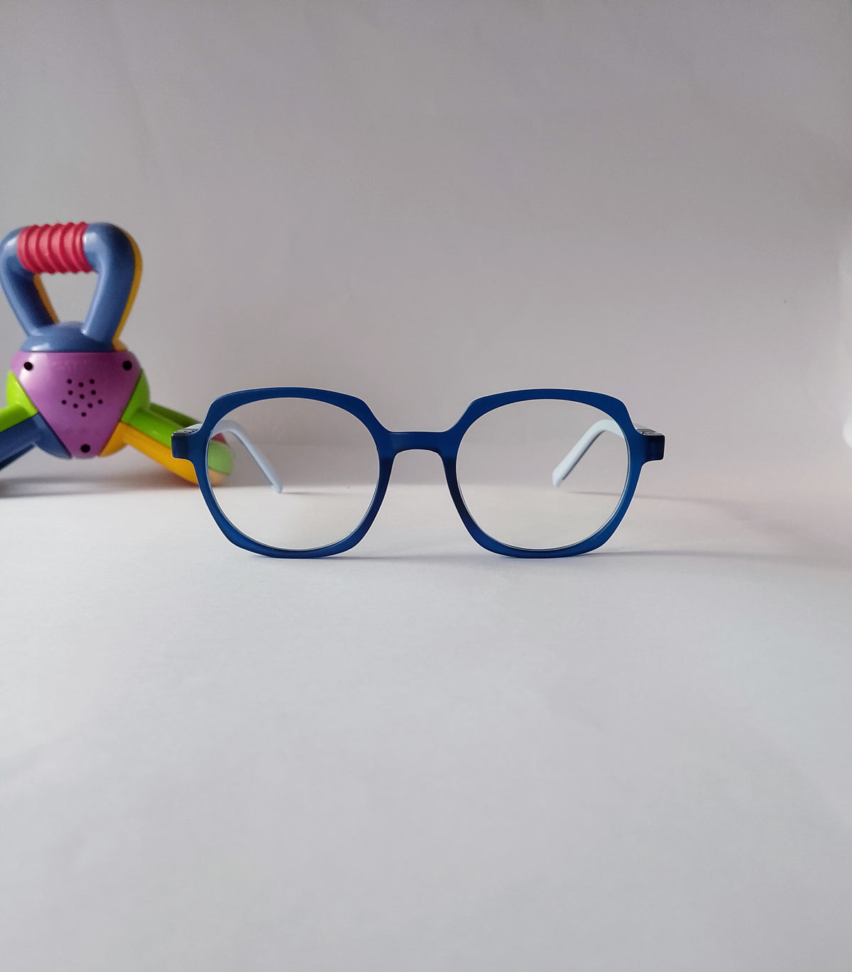 a blue geometric kids frame, front view with a toy in a background.