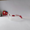 A pair of children's safety eyeglasses with clear plastic frames and red plastic temple tips, displayed on a plain white surface.