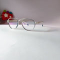A pair of round metal eyeglasses with thin silver frames and clear lenses, resting on a white surface against a light gray background.