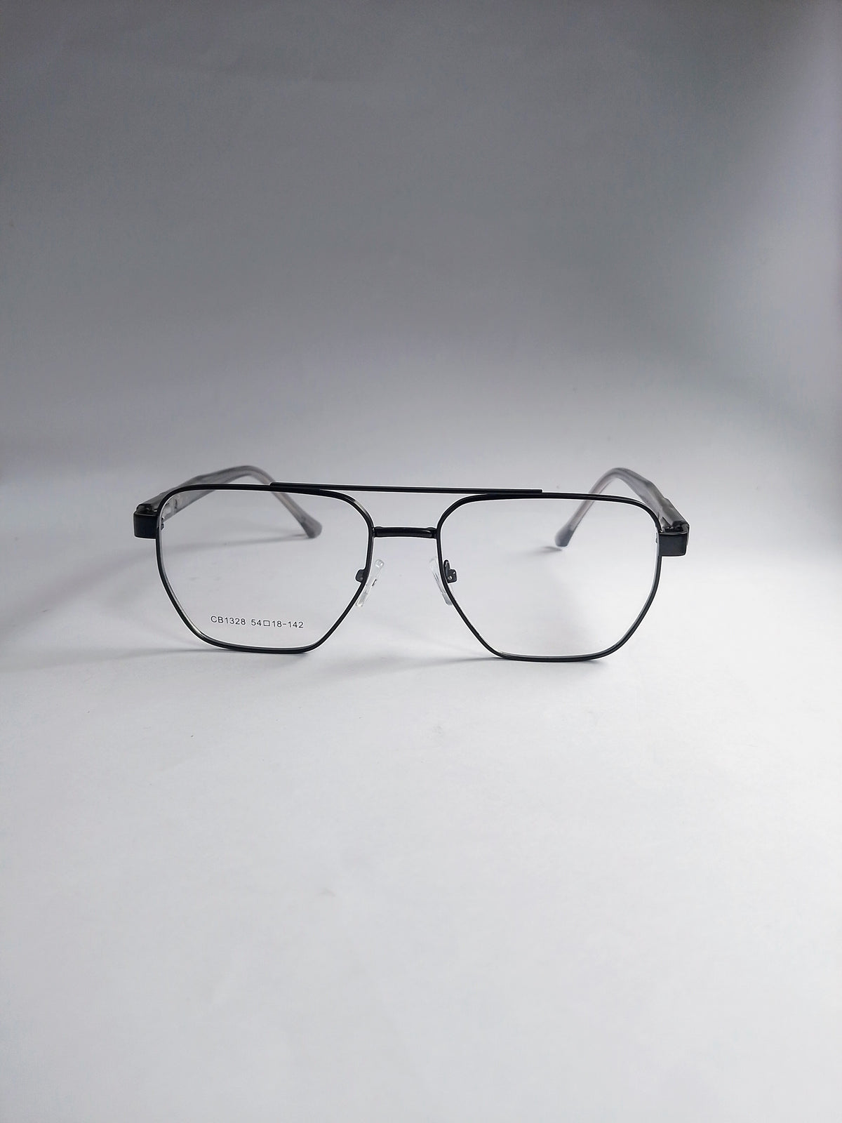 A pair of aviator-style eyeglasses with a thin black metal frame and clear lenses, displayed on a neutral gray background.