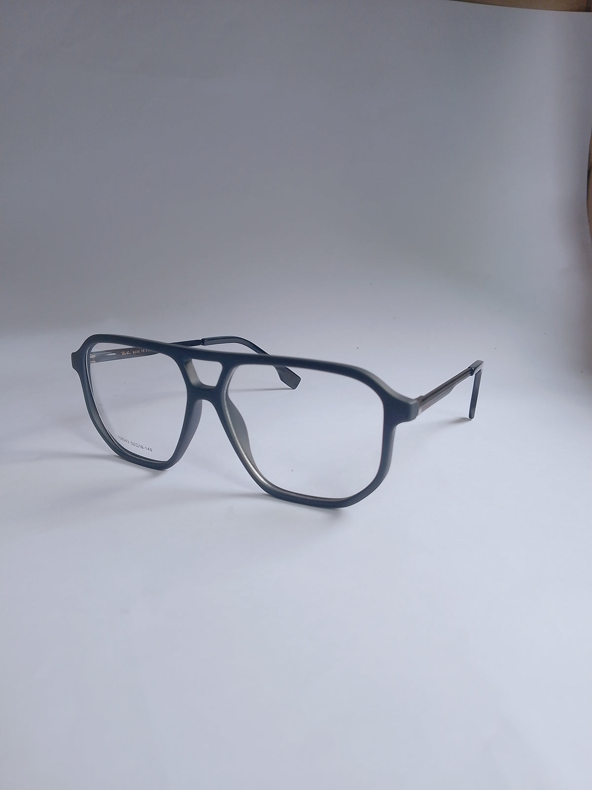 A pair of oversized square aviator-style eyeglasses with a navy acetate frame and clear lenses, resting on a light gray surface.