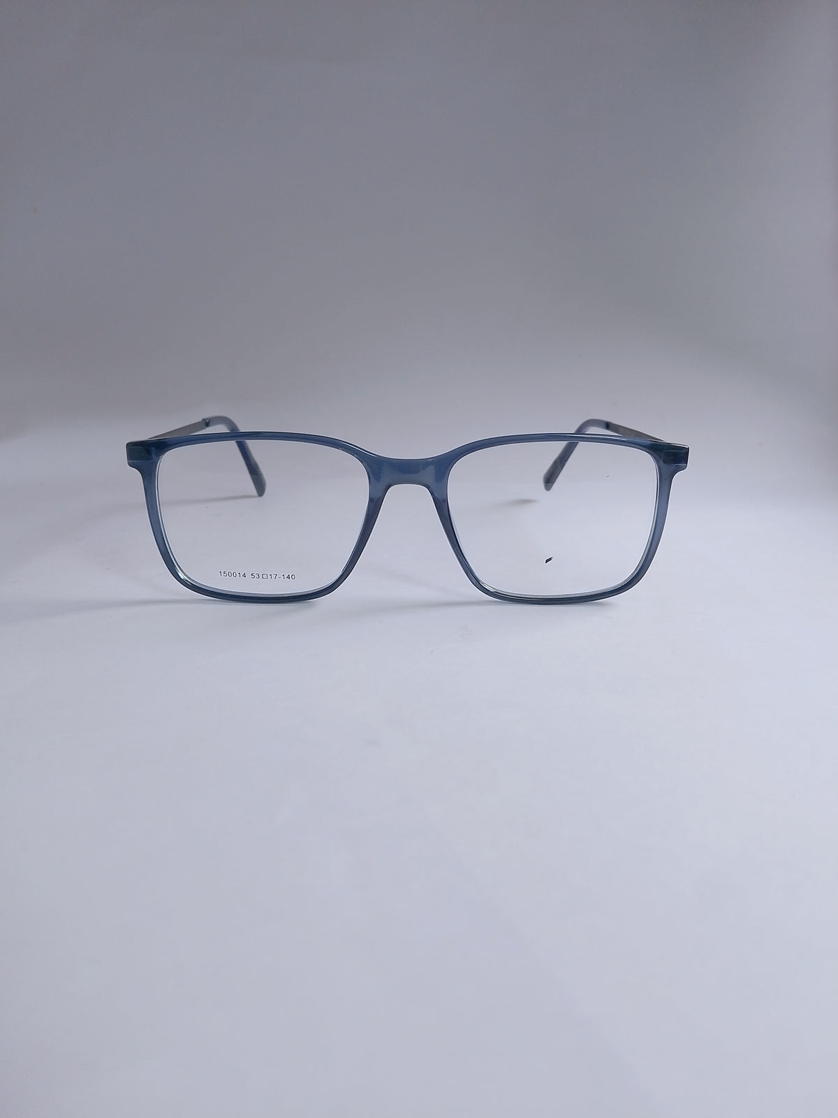 A pair of square-frame eyeglasses with a translucent dark blue acetate frame and clear lenses, displayed on a neutral light gray background.