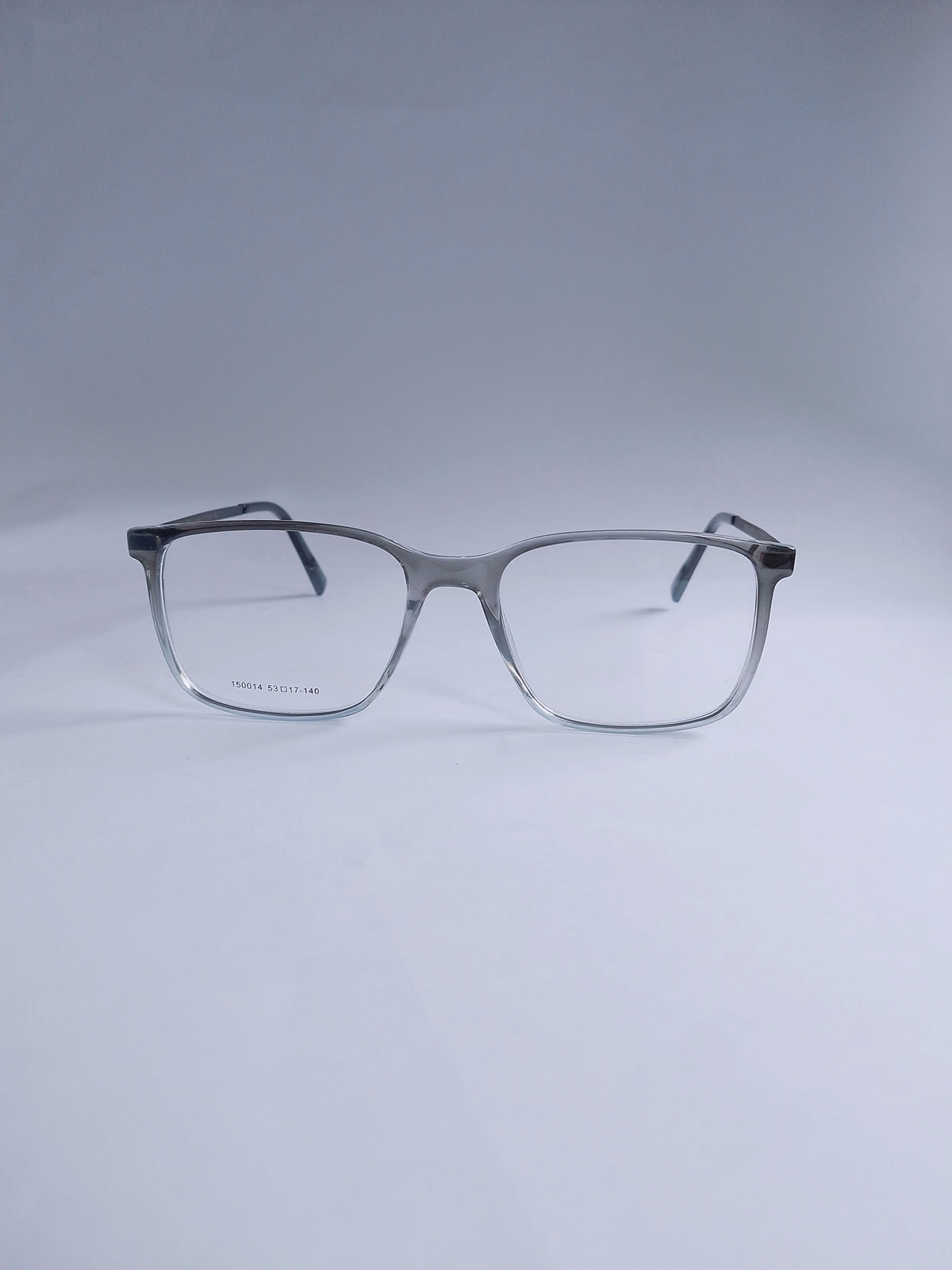A pair of square eyeglasses with a gray to white gradient acetate frame and clear lenses, displayed on a light gray studio background.
