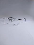 A pair of square metal eyeglass frames with clear lenses, displayed on a light gray background. Sliver to white gradient