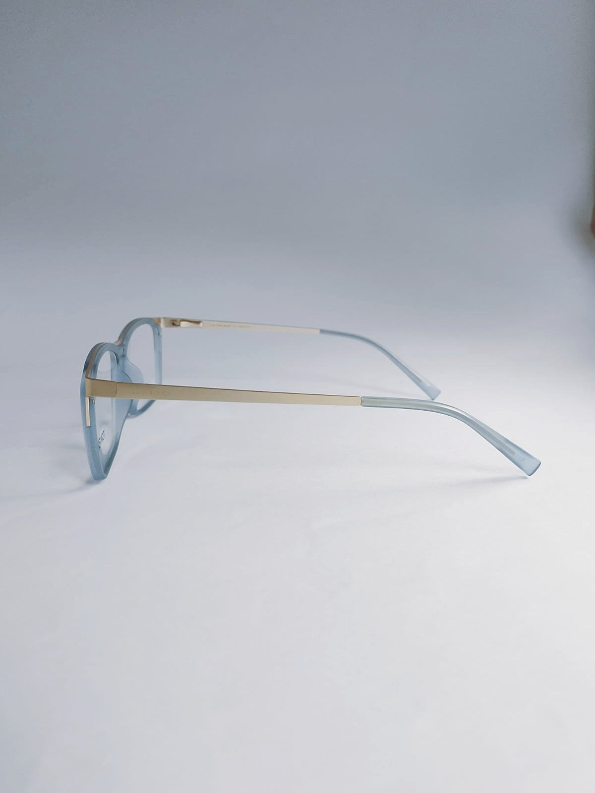Light blue acetate sunglasses with gold metal bridge and temples, displayed on a clean light gray background.