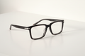 Black rectangular stylish frame with clear lenses on white surface, modern optical frames for men or women