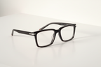 Black rectangular stylish frame with clear lenses on white surface, modern optical frames for men or women