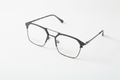 Modern black metal eyeglass frames with geometric design, clear lenses, and sleek temples on white background