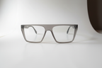 A pair of square eyeglasses with a translucent gray acetate frame and clear lenses, displayed on a clean white surface.