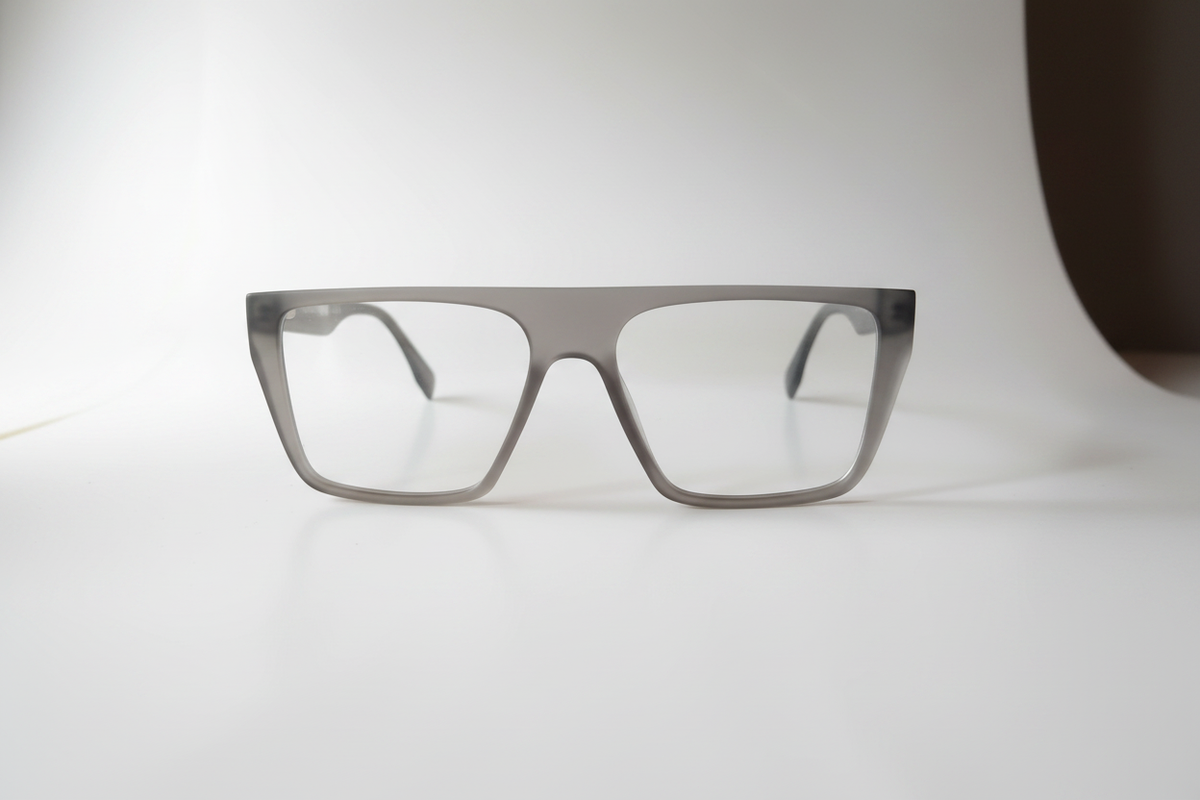 A pair of square eyeglasses with a translucent gray acetate frame and clear lenses, displayed on a clean white surface.