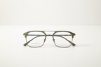 Olive green rectangular eyeglasses with thin metal frame, clear lenses, and modern geometric design on white background