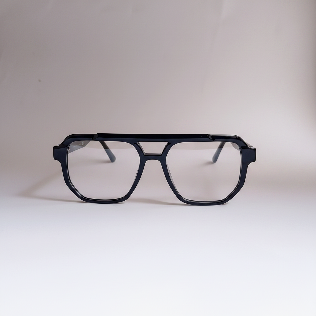 A pair of thick, angular black eyeglass frames with clear lenses, photographed from the front on a neutral light gray background.
